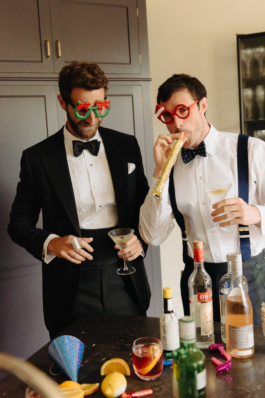 Two male models wearing Black Tie attire with drinks, party scene