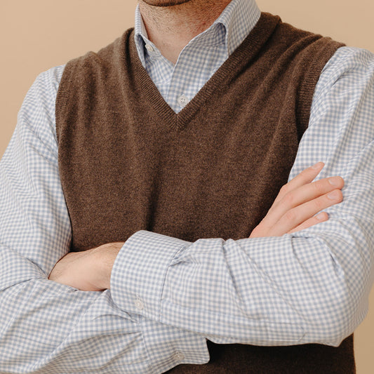 Close up of model wearing Stanhope Cashmere V-Neck Slipover in Pepperpot over gingham check shirt with arms folded