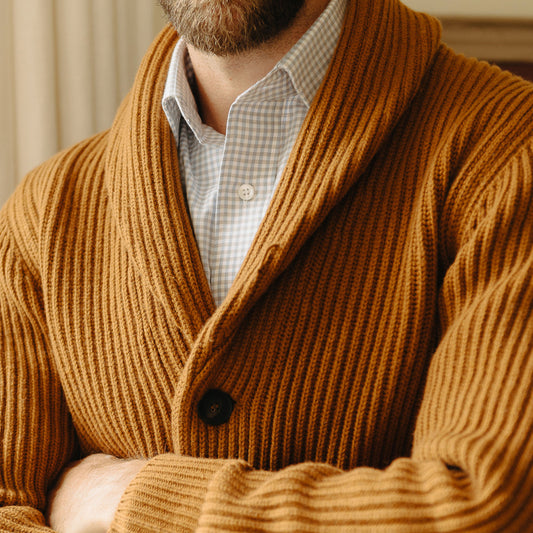 Close up image of male model stood with arms folded wearing Huntley Cashmere Shawl Neck Ribbed Knitted Cardigan in Orange showing collar and detail