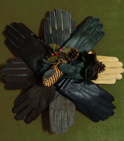 Leather and suede gloves on green background, winter walks